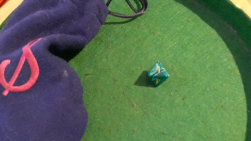 A green swirly d8, showing a '1'