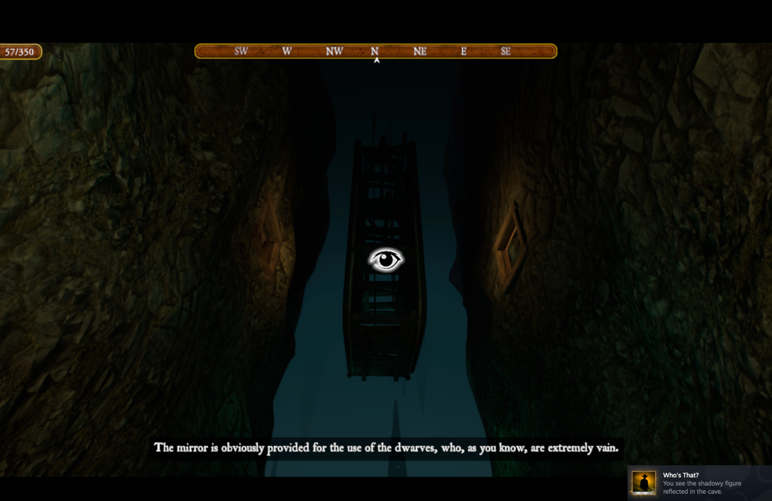 A screenshot from Colossal Cave (the 2023 3D version). The viewpoint is looking up from the bottom of a canyon. There are stone walls to the left and the right. There are lighted square indows up high in either stone wall. In the center hangs thick rectangular cuboid, the mirror viewed edge-on. It looks like there is some scaffolding or something between the two faces of the mirror. In the center, directly over the mirror, there is an eye overlay (part of the game's HUD). At the top left, a score counter "57/350". At the top, a direction indicator pointing to north. At the bottom, white text reads "The mirror is obviously provided for te use of the dwarves, who, as you know, are extremely vain. In the lower left, there is an achievement popup, the icon for which is a shadowy figure wearing a brimmed hat: "Who's That? You see the shadowy figure reflected in the cave."